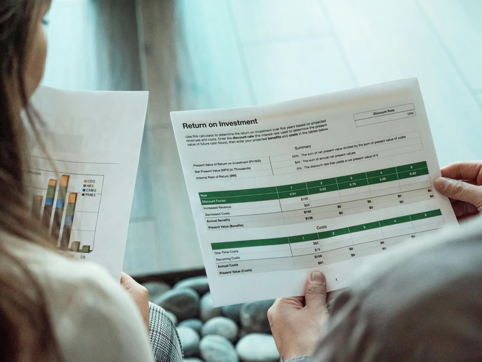 Two professionals reviewing a return on investment (ROI) report for video marketing performance.