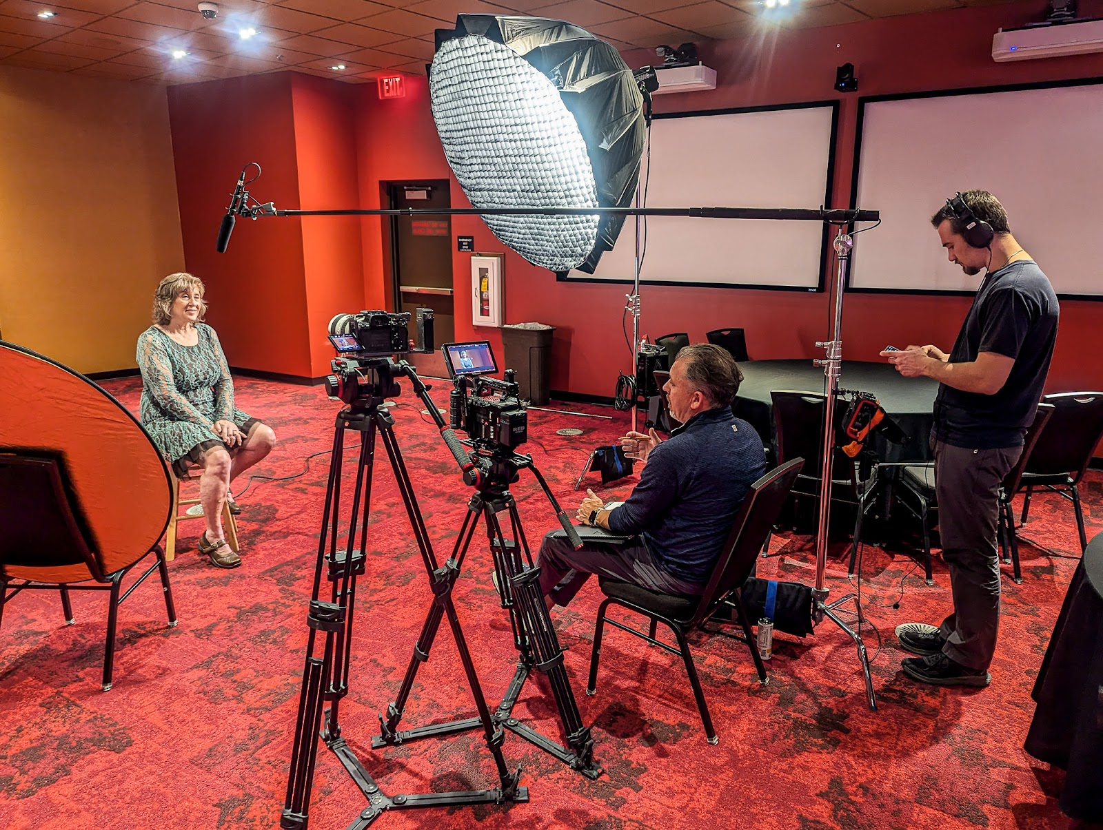Professional video production team filming an interview with cameras, lighting, and audio gear during a corporate shoot.