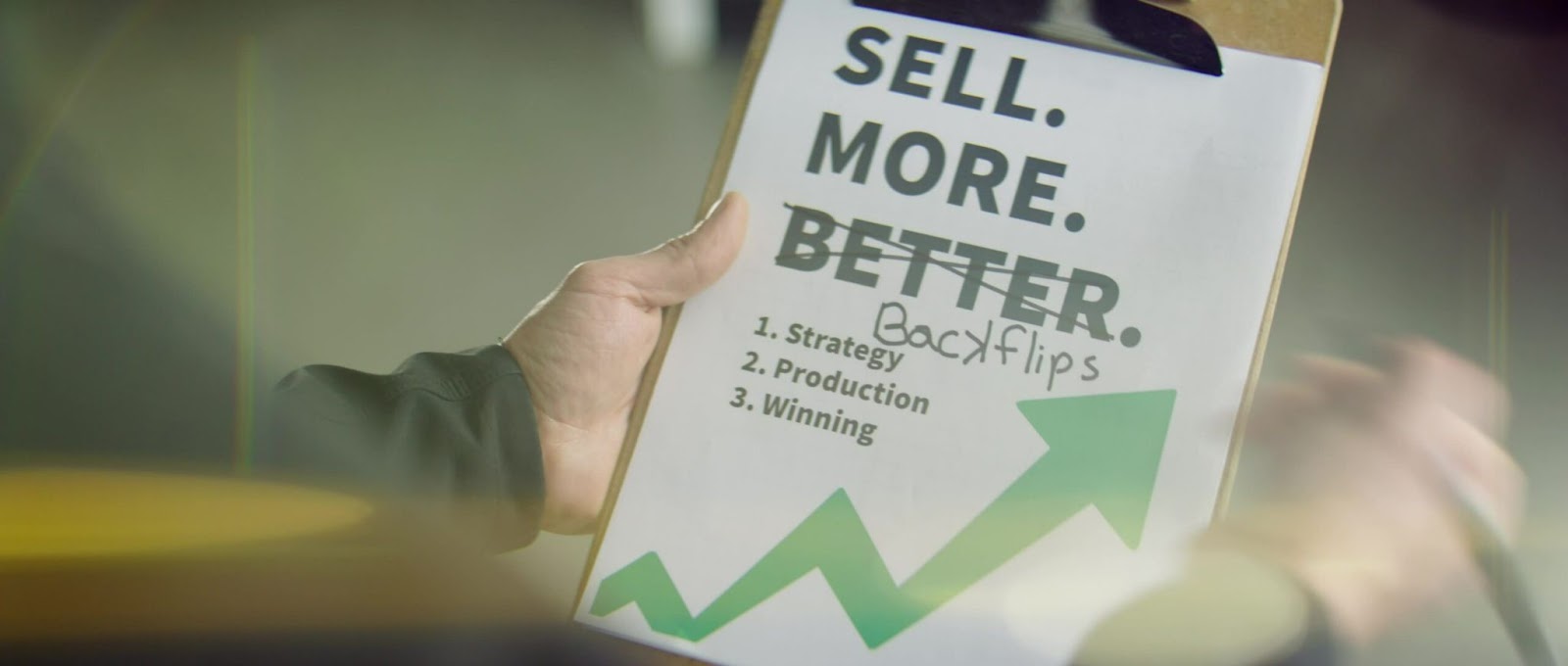 Hand holding a clipboard with a checklist for video marketing strategy including strategy, production, and audience-winning tactics.