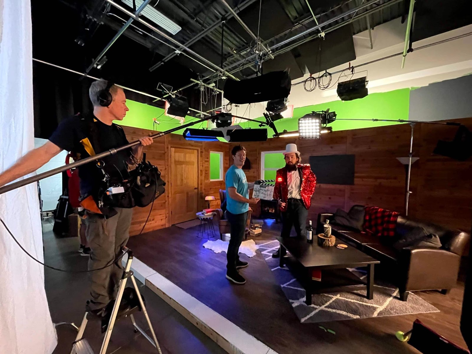 Behind-the-scenes view of a corporate video production set with lighting, crew, and a costumed actor preparing for a shoot.