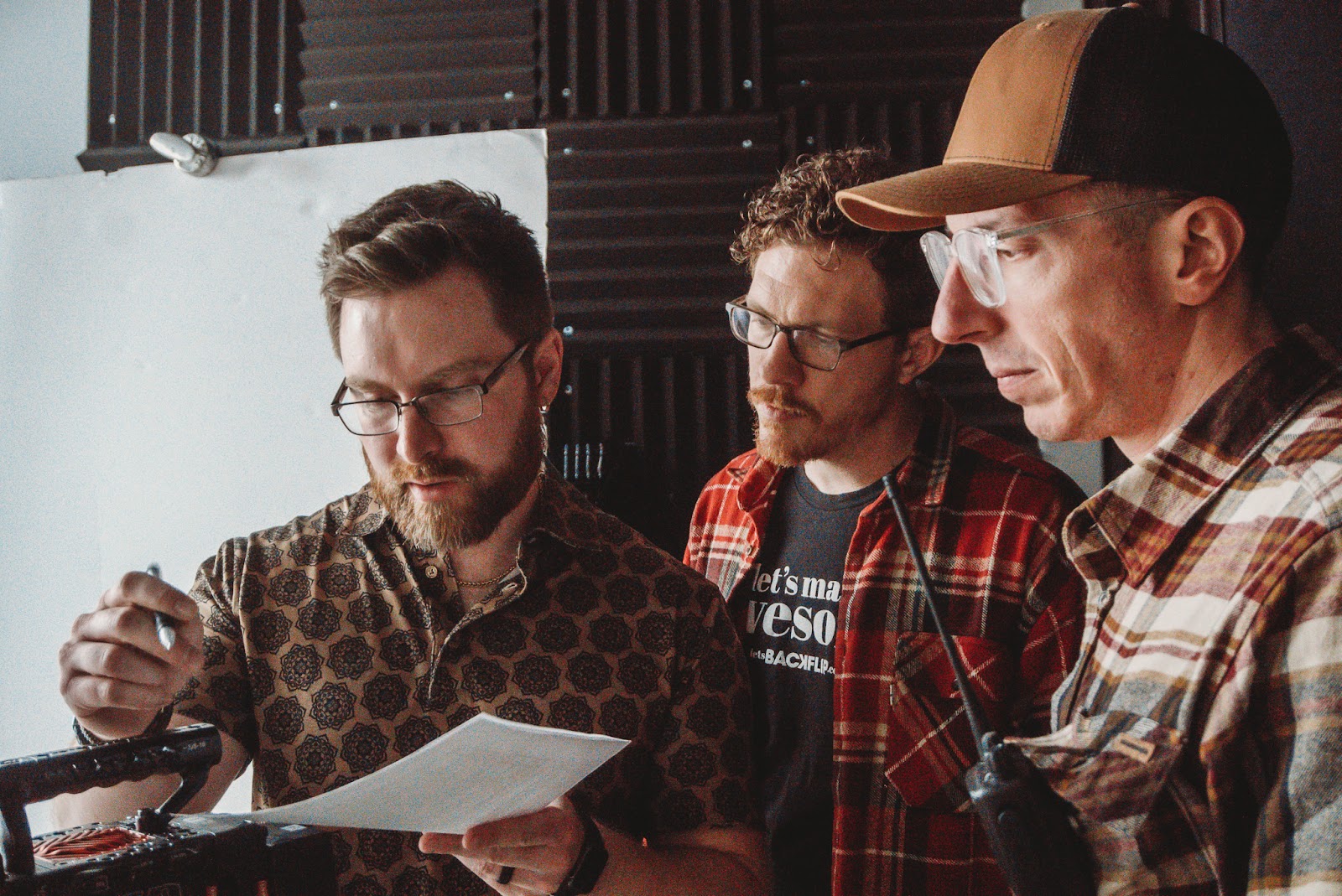 Three members of a video production team review a shoot plan during the pre-production phase of a corporate video project.