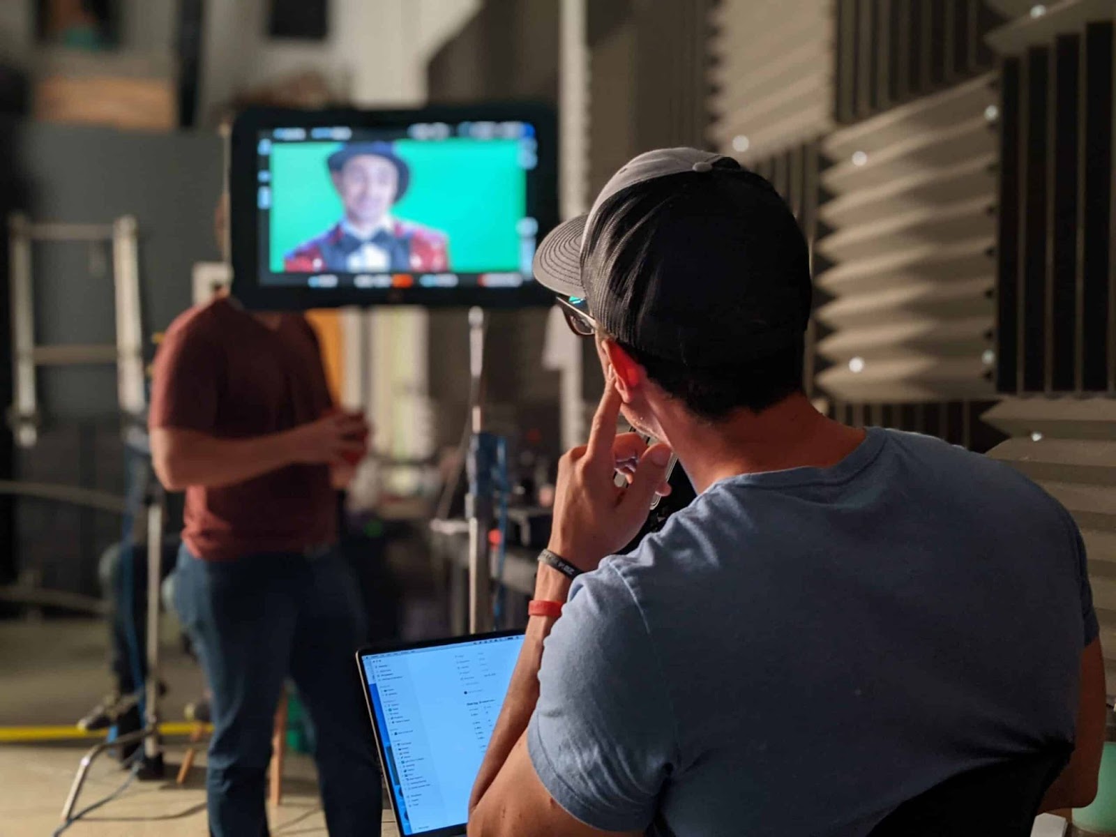 Corporate video production director reviewing live monitor feed on set during a high-quality business video shoot.