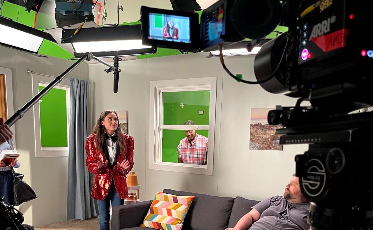 Corporate video production team filming brand storytelling content on a professional indoor set with lighting and green screen.