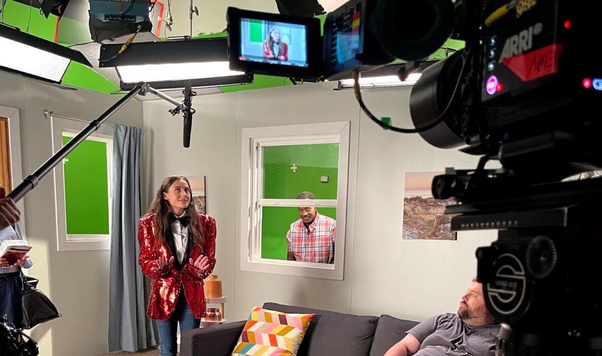 Behind-the-scenes look at corporate video production set with camera crew and actors filming branded content.