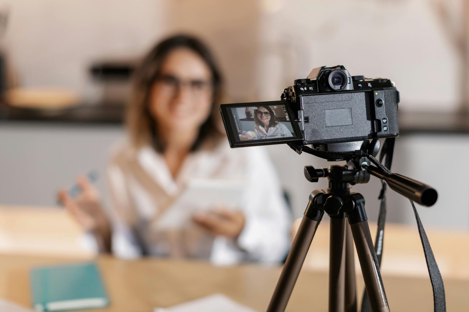 Woman creating an animated explainer video usFemale marketer recording a professional explainer video with a DSLR camera on a tripod in a modern office setup.ng a camera, laptop, and storyboard notes at home.