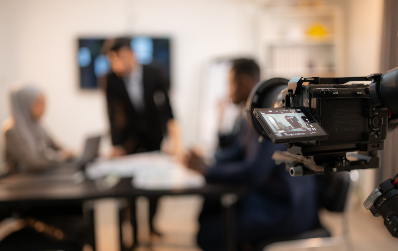 Professional camera filming small business meeting for budget video production project