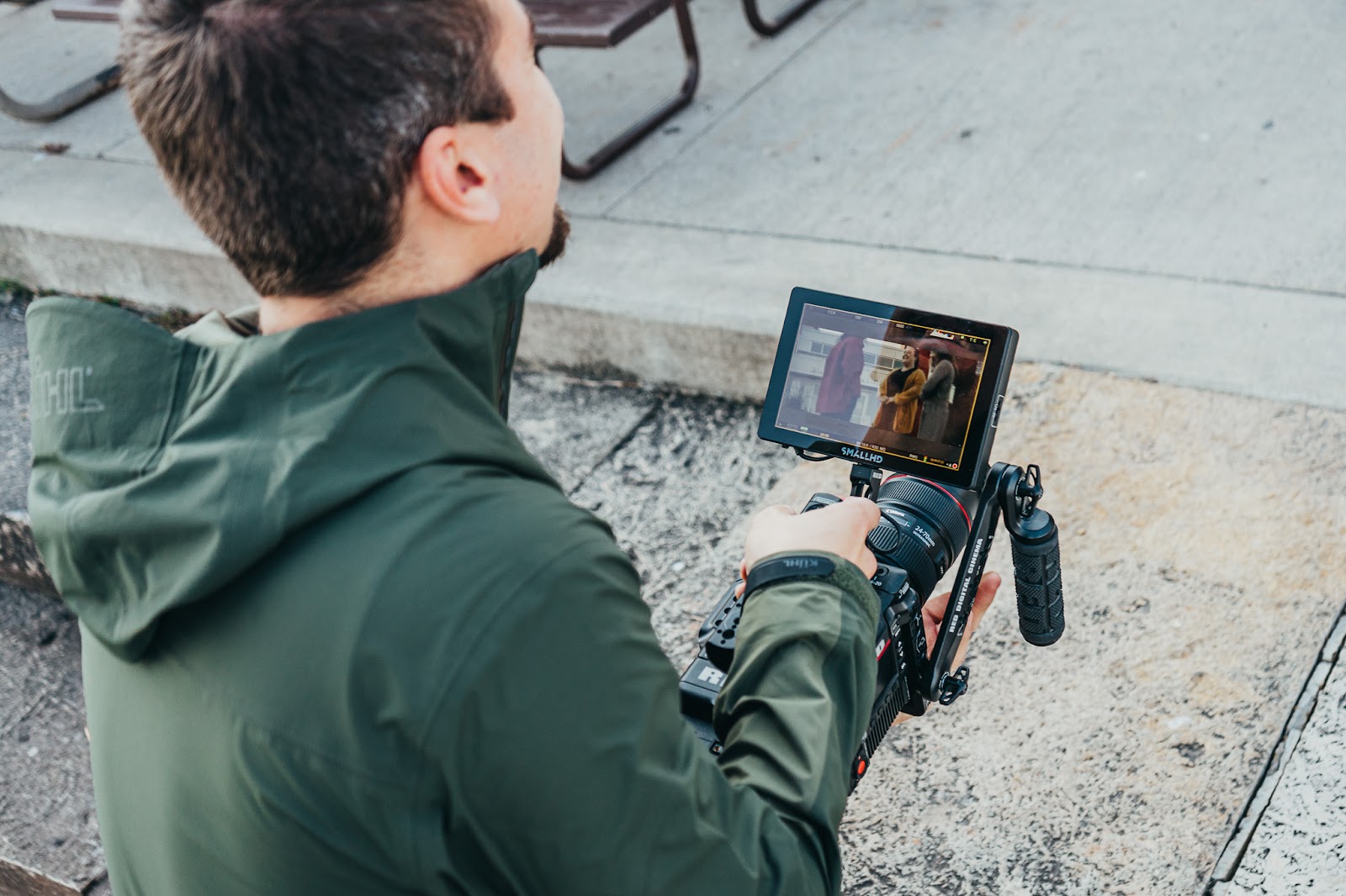 Backflip videographer capturing an outdoor client testimonial with a handheld cinema camera setup, showcasing professional video production services