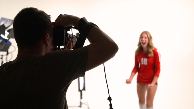 3 | Backflip Creative Marketing Photographer capturing high-energy shots of a female athlete in a professional studio, part of a branded photo campaign for a Wisconsin sports organization.