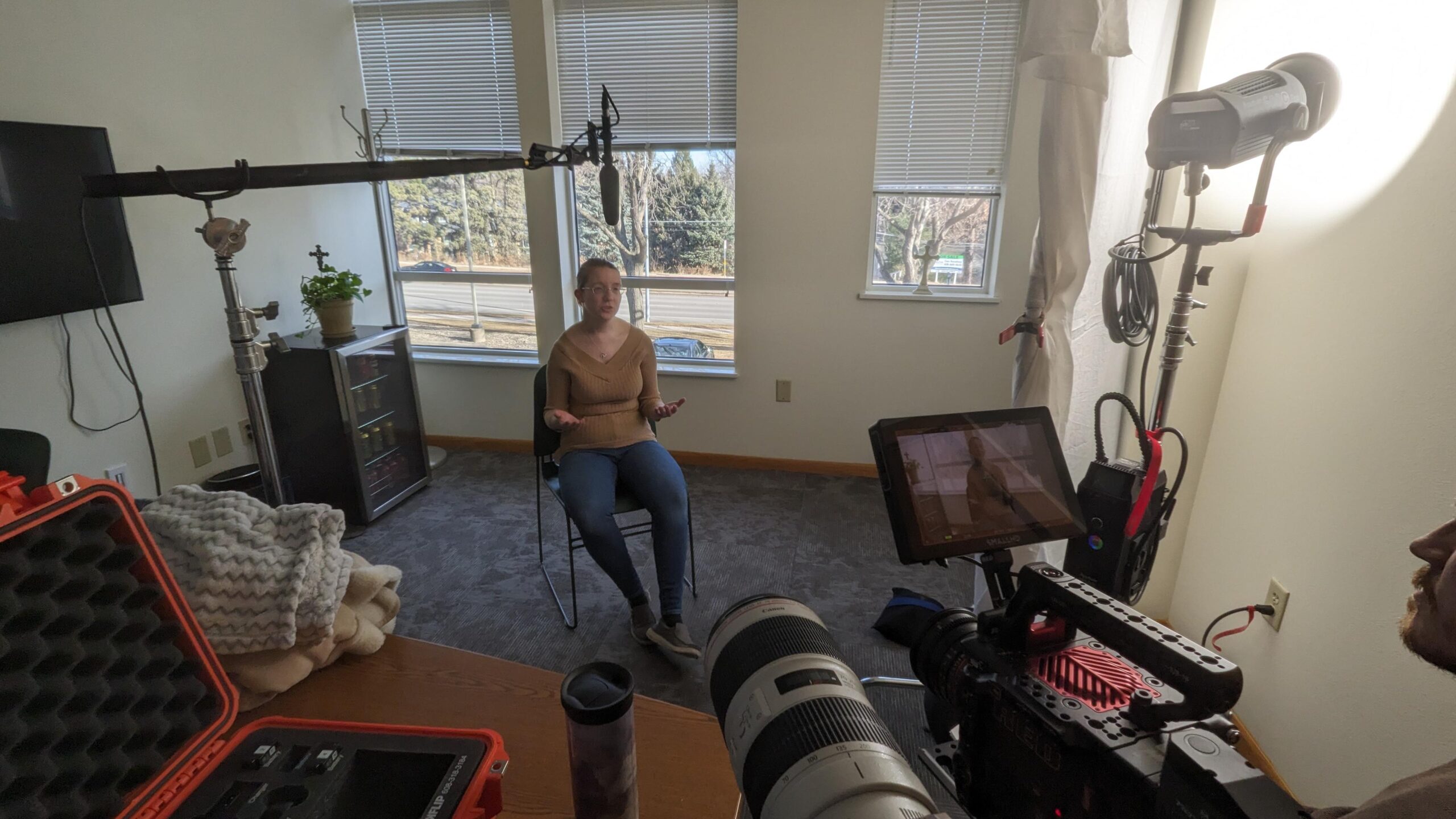 A person is sitting in an interview setup at Our Lady of Hope Clinic to film a "hero" video for future social media campaigns.