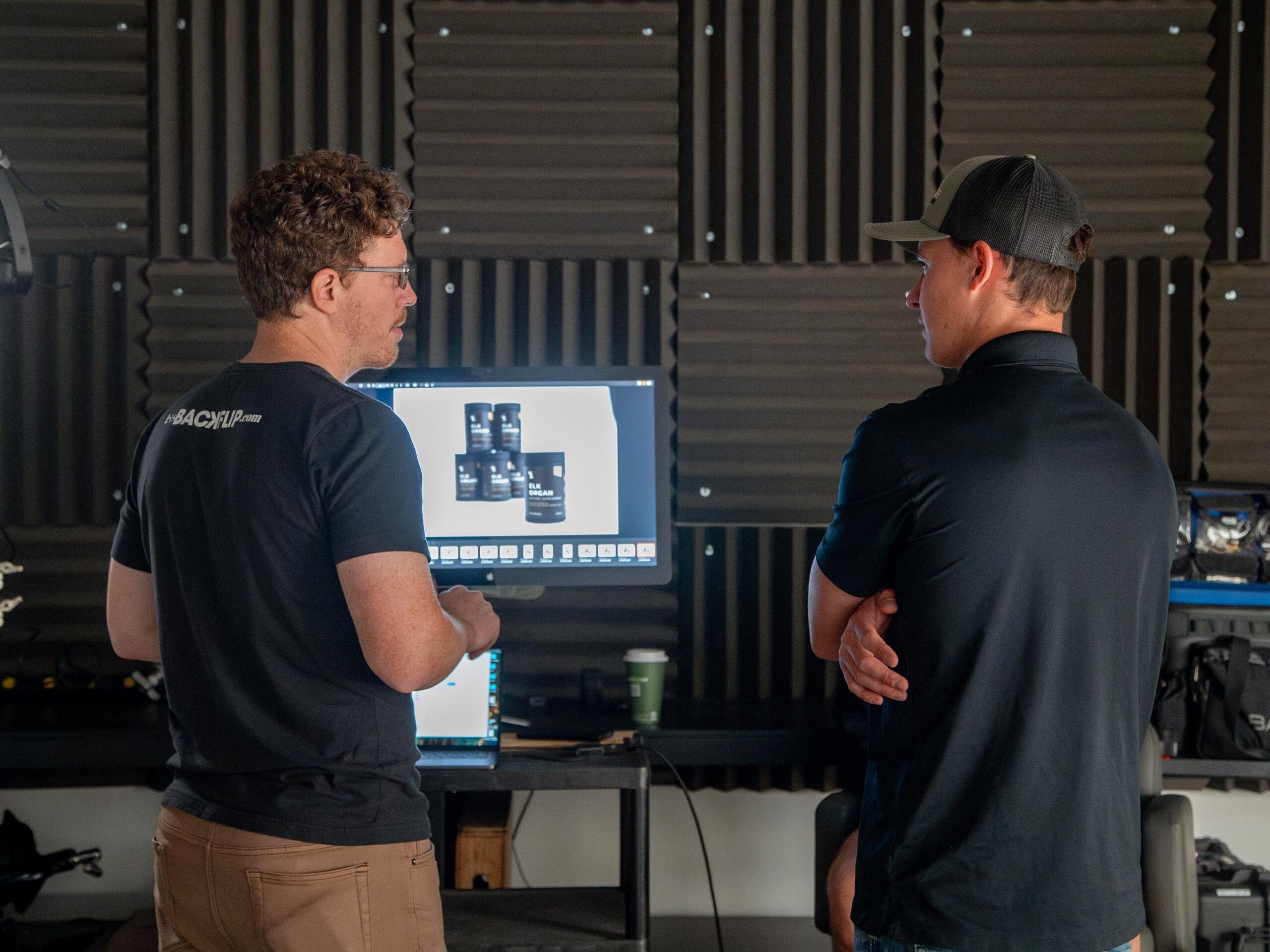 John, Backflip's creative director and co-founder, talks to one of our partners, Jade from Noble Elk, while a photo recently taken of their Elk Supplements appears on a monitor.
