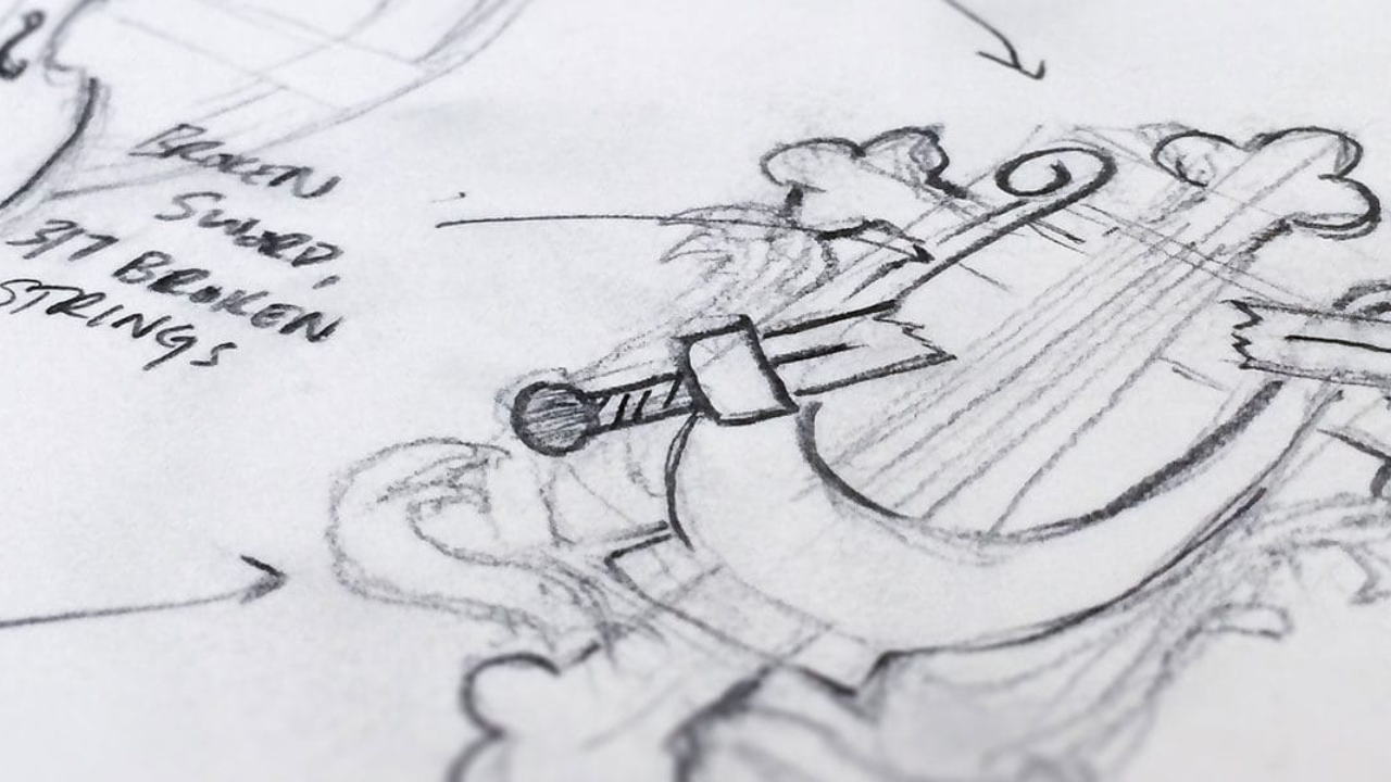 A close-up glimpse into a graphic designer's sketchbook shows the rough draft of a harp and sword logo.